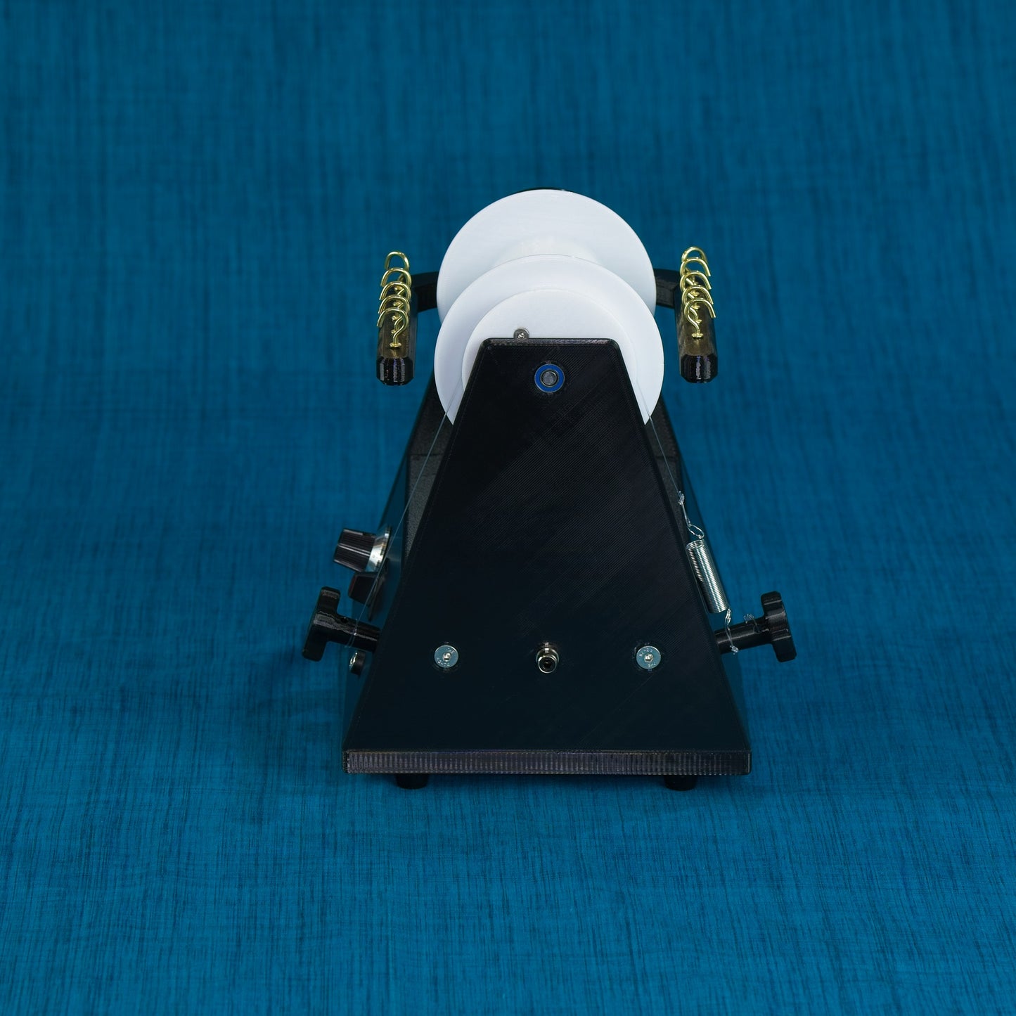 Twisted Sheep portable electric spinning wheel rear view showing tension knobs and foot pedal connector